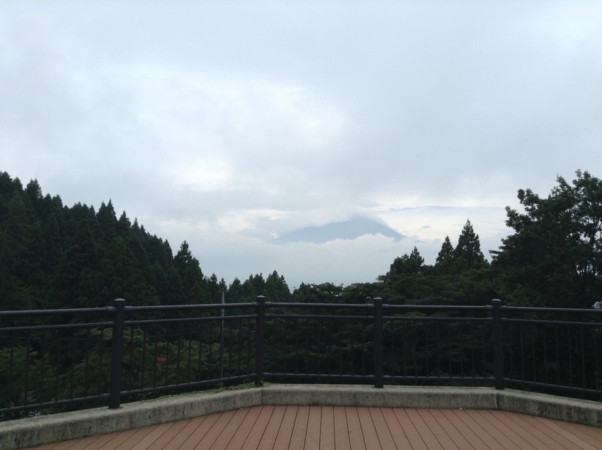 雲間に見える黒っぽい影が富士山...