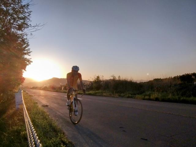 17:27。日没を背景に車に急...