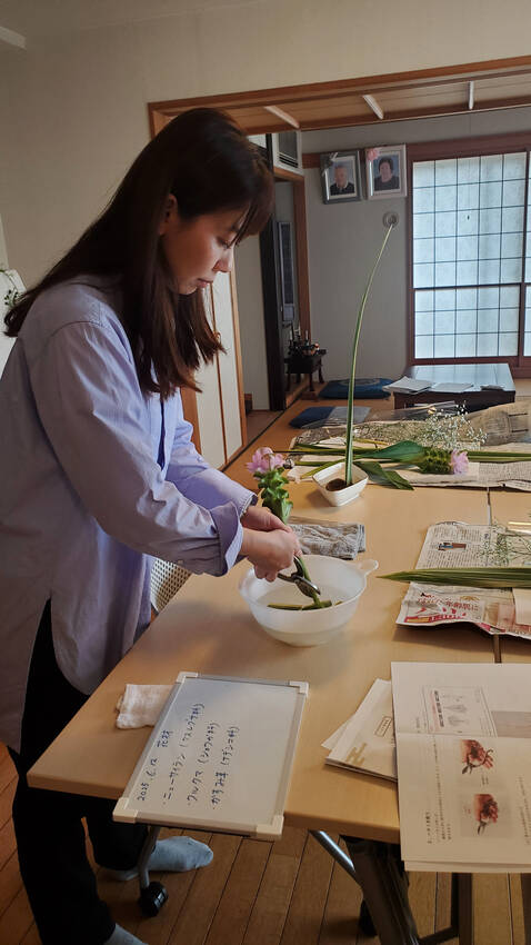 水揚げのために茎を水の中で切っ...