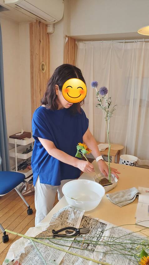 客枝のひまわりを丁寧にいけてい...