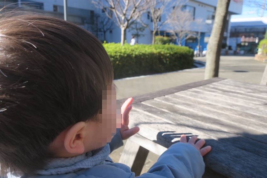 公園のテーブル付きベンチに腰か...