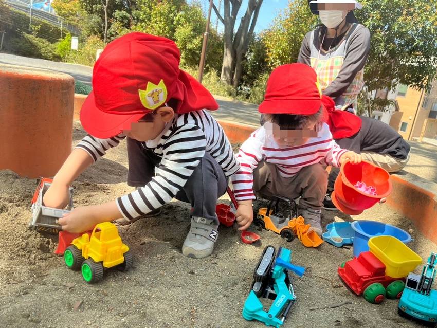 砂場で大好きな車のおもちゃで遊...