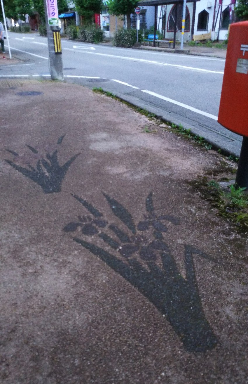 歩道にからすや花の模様が